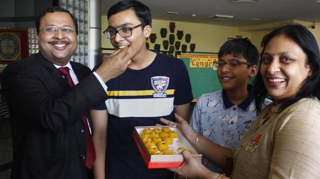 Prakhar Mittal, who secured first spot in CBSE's Class 10th examinations along with Nandini Garg, Rimzhim Aggarwal and Sreelakshmi G, being offered sweets by his parents in Gurugram on Tuesday.(PTI Photo)