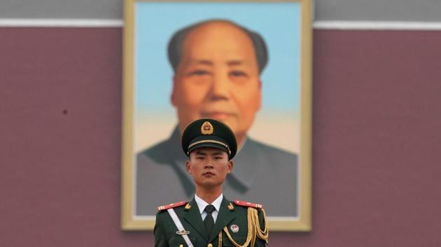 A paramilitary policeman stands guard before a giant portrait of late Chinese Chairman Mao Zedong at Tiananmen Gate. Mao continues to be deeply revered in China.(REUTERS File)