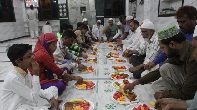 Hindus and Muslims share the iftar meal at Furqan Masjid in Mumbra on Sunday.(Praful angurde/HT)