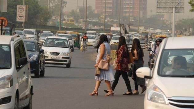 People wait for public transport near Gurugram’s Sector 31 on Delhi-Gurugram expressway on a hot summer day.(Parveen Kumar/HT Photo)