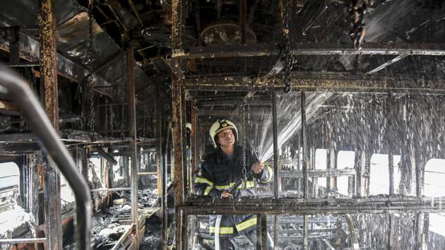 A fire-fighter douses the fire inside the coach of a train parked at Chhatrapati Shivaji Maharaj Terminus railway yard in Mumbai on Tuesday.(KUNAL PATIL/ HT PHOTO)