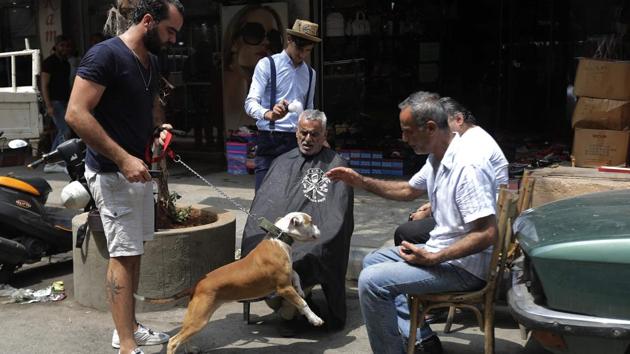 Some stop him for a haircut, others hail him down to catch up or introduce themselves. In his free time or when his shift is done, he heads out on his bike to find customers, grooming between five and 30 people a day. “The situation changes depending on the day,” he said. (Joseph Eid / AFP) Some stop him for a haircut, others hail him down to catch up or introduce themselves. In his free time or when his shift is done, he heads out on his bike to find customers, grooming between five and 30 people a day. “The situation changes depending on the day,” he said. (Joseph Eid / AFP)