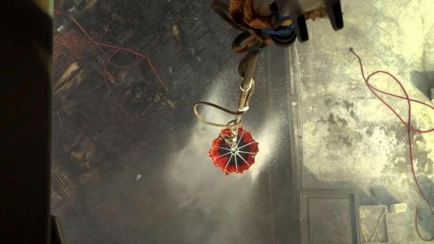 An Indian Air Force (IAF) chopper douses a fire at a godown using a ‘Bambi Bucket’ at Malviya Nagar in New Delhi on Wednesday. The massive blaze broke out at a godown on Tuesday evening. At least 70 fire tenders were used to contain the fire, said a fire officer. (PTI) 