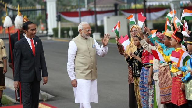 PM Narendra Modi waves at Indonesian school children waving Indonesian and Indian national flags as Indonesian President Joko Widodo looks on during the welcoming ceremony at Merdeka Palace in Jakarta, Indonesia. (Reuters Photo) PM Narendra Modi waves at Indonesian school children waving Indonesian and Indian national flags as Indonesian President Joko Widodo looks on during the welcoming ceremony at Merdeka Palace in Jakarta, Indonesia. (Reuters Photo)