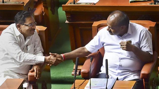 Karnataka chief minister HD Kumaraswamy and his deputy G Parameshwara greet each other after their coalition government won the trust vote by voice vote, at Vidhana Soudha in Bengaluru, on Friday.(PTI Photo)