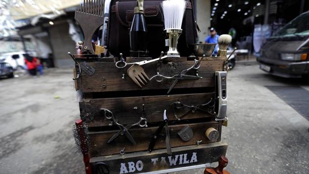 Everything he needs for a trim on the pavement is in a handmade trunk attached to the back of his pushbike: scissors, combs, electric razors and brushes. Mobile barbers were once ubiquitous in Beirut, but regular salons have since become more popular. Abo Tawila works in both, spending most of his day in a barbershop before hitting the tarmac on his bike. (Joseph Eid / AFP) Everything he needs for a trim on the pavement is in a handmade trunk attached to the back of his pushbike: scissors, combs, electric razors and brushes. Mobile barbers were once ubiquitous in Beirut, but regular salons have since become more popular. Abo Tawila works in both, spending most of his day in a barbershop before hitting the tarmac on his bike. (Joseph Eid / AFP)