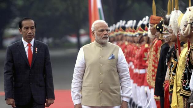 Prime Minister Narendra Modi reviews an honor guard, accompanied by Indonesian President Joko Widodo, left, during their meeting at Merdeka Palace in Jakarta, Indonesia.(AP Photo)