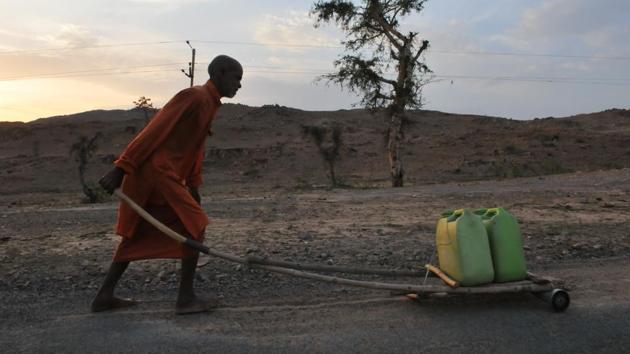 A file photo of a priest carrying water for a temple in Bundelkhand area near Prithvipur in Madhya Pradesh. Several regions of Madhya Pradesh, including Bundelkhand, has been facing acute water shortage because of scanty rainfall in last monsoon and an almost dry winter(Mujeeb Faruqui/HT File Photo)