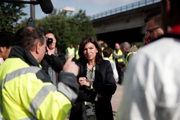 Hidalgo (C), who has paid weekly visits to the encampment, said she felt good that the migrants were being taken to shelters, but “I think we could have done without the four-month wait.” (Benoit Tessier / REUTERS) Hidalgo (C), who has paid weekly visits to the encampment, said she felt good that the migrants were being taken to shelters, but “I think we could have done without the four-month wait.” (Benoit Tessier / REUTERS)