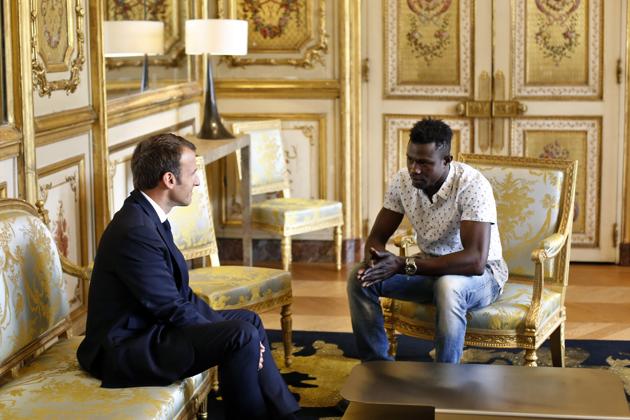 President Emmanuel Macron wants a tough response to migrants arriving in France. Just this week, he nevertheless opened the way to citizenship and a job for a Malian migrant who scaled a building and saved a young child dangling from a balcony in what he called “an exceptional act.” A video of Mamoudou Gassama’s feat went viral, gaining him the nickname “Spiderman.” (Thibault Camus / Pool / AP) President Emmanuel Macron wants a tough response to migrants arriving in France. Just this week, he nevertheless opened the way to citizenship and a job for a Malian migrant who scaled a building and saved a young child dangling from a balcony in what he called “an exceptional act.” A video of Mamoudou Gassama’s feat went viral, gaining him the nickname “Spiderman.” (Thibault Camus / Pool / AP)