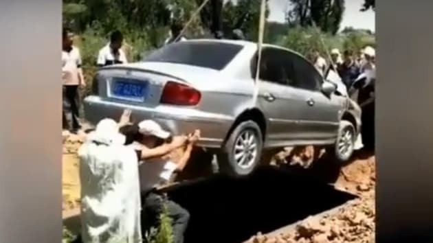 A video shows a Hyundai Sonata car bearing the man’s body hanging by ropes from an excavator as it is slowly lowered into a grave(YouTube/Screengrab)