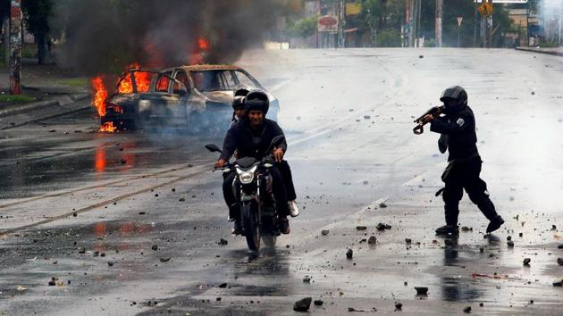 A riot police officer fires his shotgun towards two men during a protest against Nicaragua's President Daniel Ortega's government at Managua in Nicaragua on May 28, 2018. (Oswaldo Rivas / REUTERS) A riot police officer fires his shotgun towards two men during a protest against Nicaragua's President Daniel Ortega's government at Managua in Nicaragua on May 28, 2018. (Oswaldo Rivas / REUTERS)