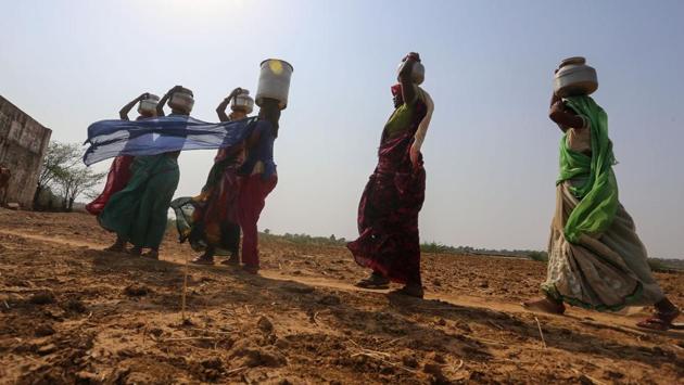 Women return after fetching water from a pit dug in the bed of Lokpal Sagar lake, near Manas Nagar village in Panna district, Madhya Pradesh on May 29, 2018. The region is experiencing a severe drought due to a shortage of rainfall in recent years. (Gagan Nayar / AFP) Women return after fetching water from a pit dug in the bed of Lokpal Sagar lake, near Manas Nagar village in Panna district, Madhya Pradesh on May 29, 2018. The region is experiencing a severe drought due to a shortage of rainfall in recent years. (Gagan Nayar / AFP)