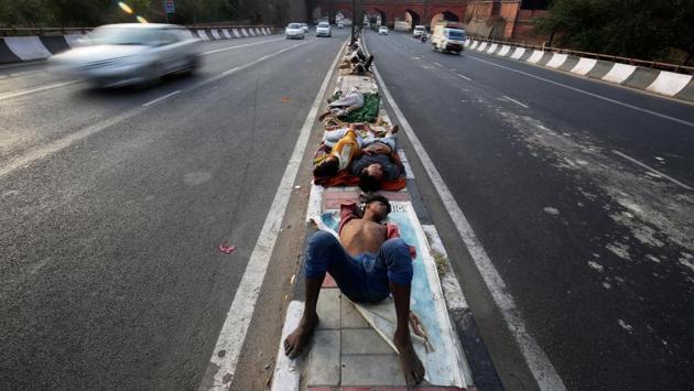 People seen sleeping on a road divider in New Delhi on June 1, 2018. (Amit Dave / REUTERS) People seen sleeping on a road divider in New Delhi on June 1, 2018. (Amit Dave / REUTERS)