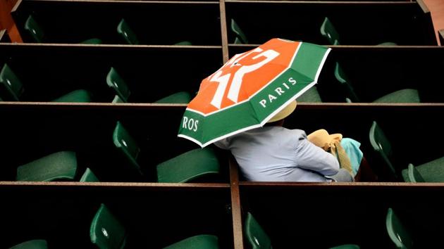 A spectator shelters under an umbrella as rain falls during the men's singles first round match between Croatia's Marin Cilic and Australia's James Duckworth on day three of the Roland Garros 2018 French Open tennis tournament in Paris on May 29, 2018. (Christophe Simon / AFP) A spectator shelters under an umbrella as rain falls during the men's singles first round match between Croatia's Marin Cilic and Australia's James Duckworth on day three of the Roland Garros 2018 French Open tennis tournament in Paris on May 29, 2018. (Christophe Simon / AFP)