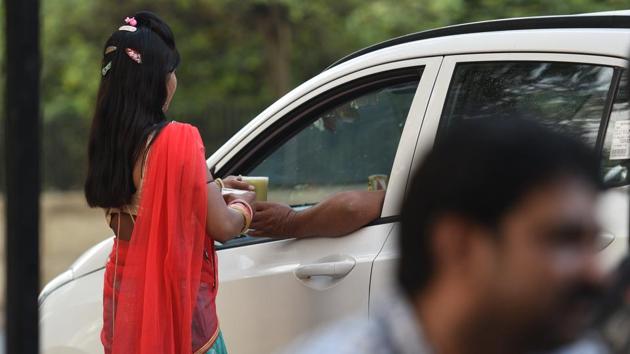 Ramgani, a 17-year-old from Datunda, serves a glass of juice to a customer in the car. Ramgani and her sister Pinki earns around Rs.800 – 1000 per day and on being asked if they ever felt uncomfortable while working, Ramgani said, “That it does not affect me at all, as long as I ensure each person buys no less than 7-8 glasses. And in case someone behaves indecently, I have by father and brother along to tackle them.” (Raj K Raj / HT Photo) 