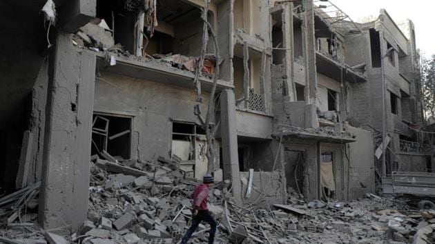 A Syrian boy walk past destruction following government air strikes in the Eastern Ghouta rebel-held enclave of Douma. (AFP File Photo) A Syrian boy walk past destruction following government air strikes in the Eastern Ghouta rebel-held enclave of Douma. (AFP File Photo)
