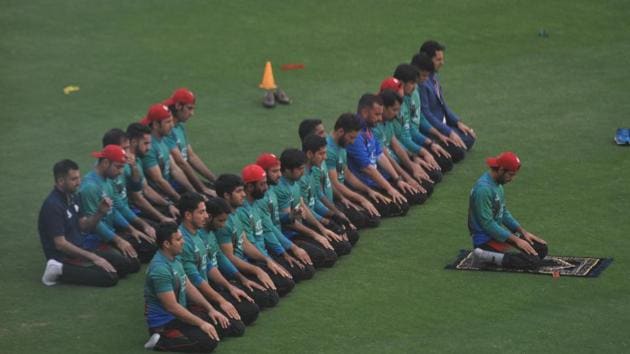 Afghanistan players offer prayers on the ground before their match at against Bangladesh at Rajiv Gandhi International Cricket Stadium in Dehradun on Sunday.(Vinay Santosh Kumar/ HT)