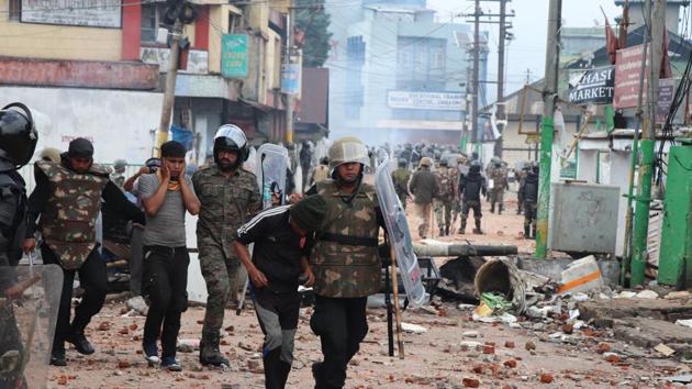 Security personnel stand guard a street during curfew in Shillong on Sunday.(HT Photo)