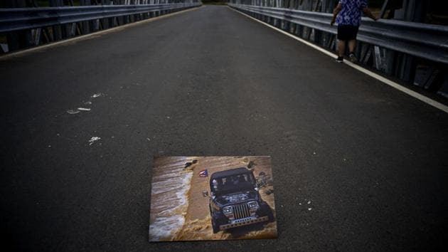 A photograph of a jeep crossing a river on October 7, 2017 is placed on the new bridge that stands where the storm washed out the old one. Because of its collapse, people on both sides were left stranded, turning a 45 minute commute to the other side into a three hour odyssey. (Ramon Espinosa / AP)