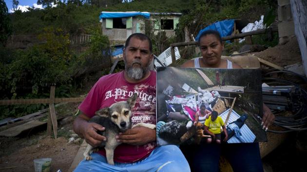 William Fontan Quintero and his wife Yadira Sostre in Morovis pose with a printed photo shot in their home destroyed by the hurricane last year. Since then, they’ve built a small wooden house with help from family where they live with their two children. Like many, they are still waiting for FEMA’s approval to build a permanent house. (Ramon Espinosa / AP)