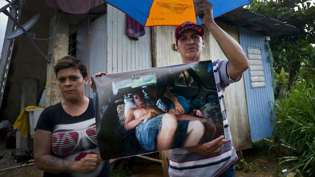 Blanca Rivera and Eduard Rodriguez hold a photo of them that was taken on September 30, 2017 as they slept in their car after their home was destroyed by Hurricane Maria. The couple said they sold their car to build a room after FEMA rejected their request for financial help to rebuild their home, “It’s sad,” Rodriguez said. “So sad.” (Ramon Espinosa / AP)