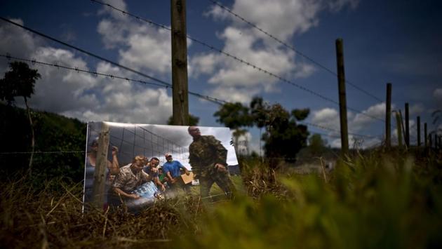 A photo print is kept at the same spot where Puerto Rican National Guards delivered food and water to desperate residents in the aftermath of Hurricane Maria on a farm in Morovis. For two months after the storm’s passing, stranded residents would come to this spot for supplies handed out by the National Guard. (Ramon Espinosa / AP)