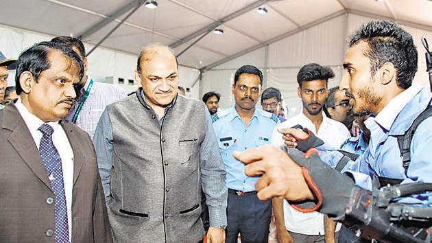 Bhushan Darekar, COEP student (right), explaining the working of the compressed air powered human exoskeleton to S Christopher, chairman, DRDO (left) and PK Mehta (2nd from left), director general, armament and combat engineering systems, DRDO.(HT PHOTO)