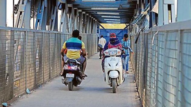 Bike riders approach from both sides on a foot overbridge leaving no space for people to walk. The Iffco Chowk FoB is accessed more by bikers than pedestrians to cross the road. (Parveen Kumar/HT Photo) Bike riders approach from both sides on a foot overbridge leaving no space for people to walk. The Iffco Chowk FoB is accessed more by bikers than pedestrians to cross the road. (Parveen Kumar/HT Photo)