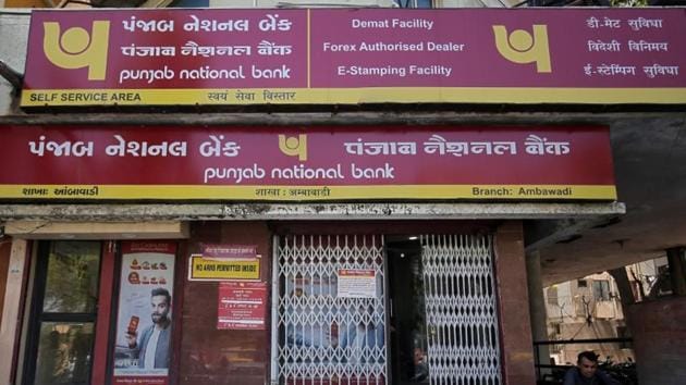 A man reads a newspaper outside a branch of Punjab National Bank (PNB) in Ahmedabad.(Reuters File Photo)