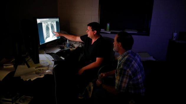 Dr. Brandon Crum explains chest x-rays to former coal miner Wade Pauley, who has black lung disease after working 33 years underground in mines. Ex-miners and regional health experts blame the resurgence on longer hours spent in deeper parts of old, played-out mines, along with lax safety measures and the use of heavy machines to blast through layers of rock. (Brian Snyder / REUTERS) Dr. Brandon Crum explains chest x-rays to former coal miner Wade Pauley, who has black lung disease after working 33 years underground in mines. Ex-miners and regional health experts blame the resurgence on longer hours spent in deeper parts of old, played-out mines, along with lax safety measures and the use of heavy machines to blast through layers of rock. (Brian Snyder / REUTERS)