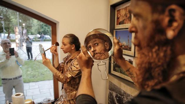 Ukranian artists apply make-up before heading out to perform in the Living Statues International Festival. Artists from eight countries embodied 64 statues in the old quarter of the Romanian capital, in popular parks and in the garden of the spectacular Filipescu-Cesianu residence, built in 1892 in the Belle Epoque period. (Vadim Ghirda / AP) Ukranian artists apply make-up before heading out to perform in the Living Statues International Festival. Artists from eight countries embodied 64 statues in the old quarter of the Romanian capital, in popular parks and in the garden of the spectacular Filipescu-Cesianu residence, built in 1892 in the Belle Epoque period. (Vadim Ghirda / AP)