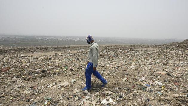 A municipal corporation official walks on a mountain formed by garbage at a landfill site ahead of the World Environment Day at Okhla in New Delhi. (Burhaan Kinu / HT Photo) A municipal corporation official walks on a mountain formed by garbage at a landfill site ahead of the World Environment Day at Okhla in New Delhi. (Burhaan Kinu / HT Photo)
