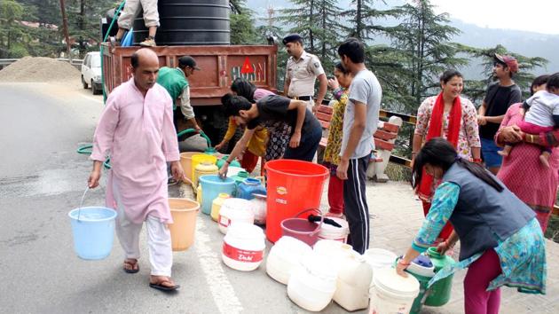 People filling water from a water tanker in Fagli, Shimla on June 1.(HT Photo)