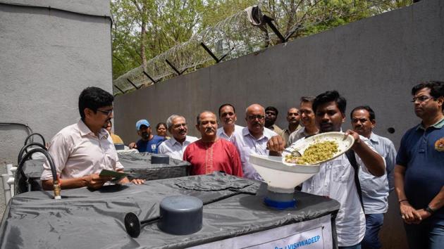 Alumni of BMCC inaugurate the machine which can convert waste food into biogas at the college on Monday.(SANKET WANKHADE/HT PHOTO)