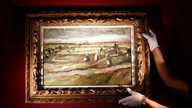 An Artcurial employee poses as he holds the painting «Raccommodeuses de filets dans les dunes, 1882» (Women Mending Nets in the Dunes) by Vincent Van Gogh.(REUTERS) An Artcurial employee poses as he holds the painting «Raccommodeuses de filets dans les dunes, 1882» (Women Mending Nets in the Dunes) by Vincent Van Gogh.(REUTERS)