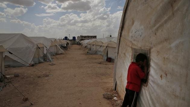 A Syrian child peeks inside a tent at the al-Bab camp. With the new arrivals, the camp of more than 280 tents grew to include 44 new communal tents, each housing up to 50 people with men and women living separately. There is no room for a kitchen and no money to buy extra food or treat those wounded by war. (Lefteris Pitarakis / AP) A Syrian child peeks inside a tent at the al-Bab camp. With the new arrivals, the camp of more than 280 tents grew to include 44 new communal tents, each housing up to 50 people with men and women living separately. There is no room for a kitchen and no money to buy extra food or treat those wounded by war. (Lefteris Pitarakis / AP)