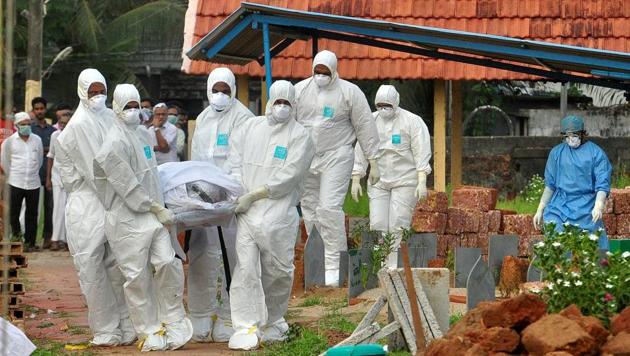 Doctors and relatives wearing protective gear carry the body of a Nipah virus victim during his funeral at a burial ground in Kozhikode, on May 24, 2018.(Reuters) Doctors and relatives wearing protective gear carry the body of a Nipah virus victim during his funeral at a burial ground in Kozhikode, on May 24, 2018.(Reuters)