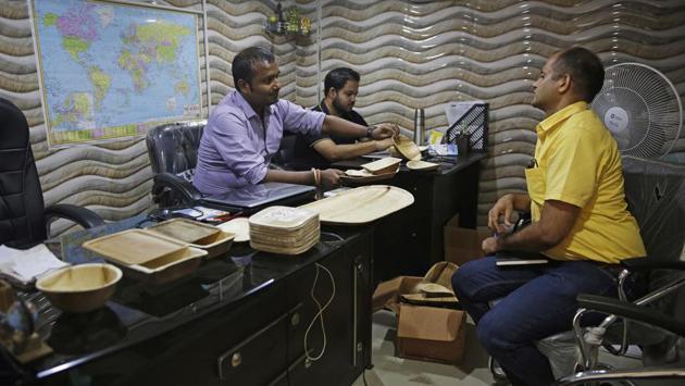 Vaibhav Jaiswall (L) and Amardeep Bardhan (2L) who run Prakritii, an eco-friendly dinnerware manufacturer, showcase biodegradable alternatives to a customer at their office in New Delhi. Prakritii, makes plates and bowls only from leaves shed by areca palm trees. The plateware, which has the feel of thick paper plates, biodegrades in seven to ten days. (Altaf Qadri / AP) Vaibhav Jaiswall (L) and Amardeep Bardhan (2L) who run Prakritii, an eco-friendly dinnerware manufacturer, showcase biodegradable alternatives to a customer at their office in New Delhi. Prakritii, makes plates and bowls only from leaves shed by areca palm trees. The plateware, which has the feel of thick paper plates, biodegrades in seven to ten days. (Altaf Qadri / AP)
