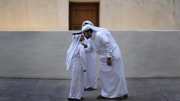 A Qatari man greets a boy in traditional Gulf Arab style in the Msheireb district of Doha. Saudi Arabia, Egypt, the United Arab Emirates and Bahrain severed diplomatic ties and transport links to Qatar last year over its alleged support of terrorist groups and warm relations with Iran. But natural gas reserves and close allies in the region have allowed Qatar to weather the crisis. (Kamran Jebreili / AP)