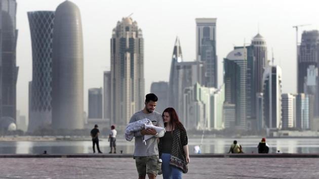 A couple takes a walk with their new born baby along the waterfront in Doha. For the citizens Sheikh Tamim remains a symbol of Qatar’s independence and defiance of the boycott. President Donald Trump, who at times has appeared to side with the boycotting nations, welcomed the emir to the White House in April. (Kamran Jebreili / AP)