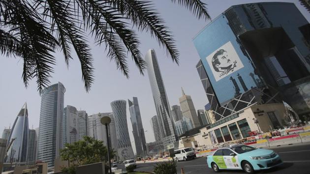 A taxi passes by a building with the image of the Emir of Qatar, Sheikh Tamim bin Hamad Al Thani, in Doha, Qatar. Across the glittering high-rise towers of the middle eastern nation, the face of the country’s ruler still seems to be everywhere a year after Arab nations imposed a boycott on his tiny, gas-rich country. (Kamran Jebreili / AP)