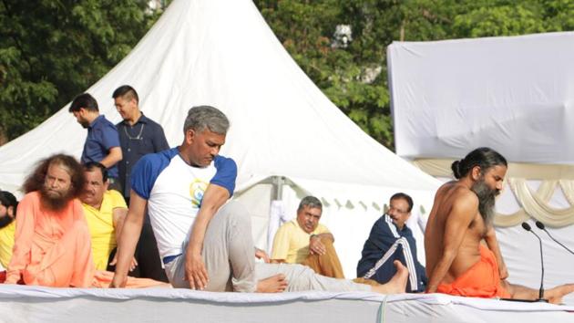 CM Trivendra Singh Rawat and yoga guru Ramdev at the rehearsal session, ahead of the International Yoga Day, in Dehradun on Thursday.(HT Photo)