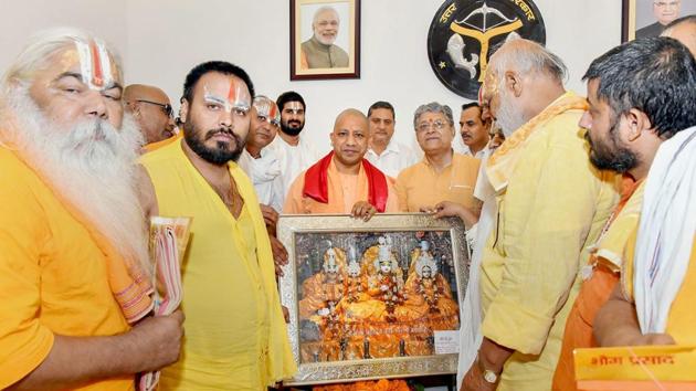 UP chief minister Yogi Adityanath poses with a delegation of sadhus and saints during a meeting over early construction of Ram Temple at Ayodhya. Taking note of alleged irregularities in wheat purchase and distribution of food grains, Uttar Pradesh Chief Minister Yogi Adityanath on Thursday suspended the district magistrates of Fatehpur and Gonda. (PTI)