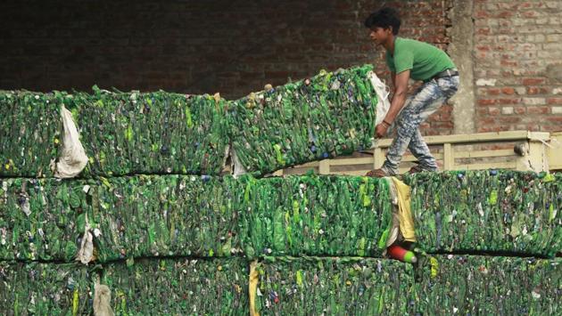 A worker loads bundles of plastic bottles onto a truck for recycling at an industrial area on the outskirts of Jammu, on June 5, 2018. (Channi Anand / AP) A worker loads bundles of plastic bottles onto a truck for recycling at an industrial area on the outskirts of Jammu, on June 5, 2018. (Channi Anand / AP)
