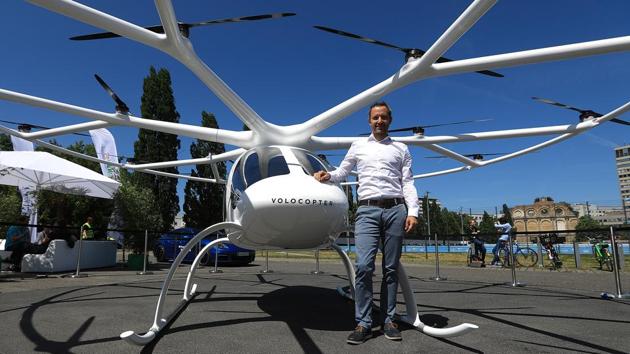 Florian Reuter, chief executive officer of Volocopter GmbH, poses for a photograph beside a Volocopter 2X multi-rotor electric helicopter at the Noah Technology Conference in Berlin, Germany, on Wednesday.(Krisztian Bocsi/Bloomberg)