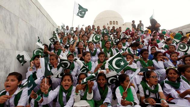 Attendees wave Pakistan's national flag while singing national songs at a ceremony to celebrate the country's 70th Independence Day at the mausoleum of Muhammad Ali Jinnah in Karachi, Pakistan.(REUTERS Representative Photo)