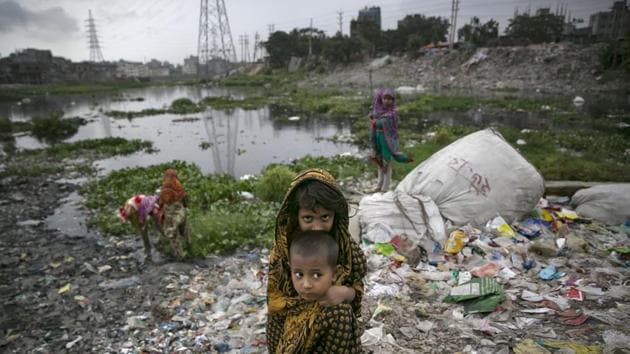 Children are seen at a plastic factory on the banks of a canal which empties into the Buriganga river in Dhaka, Bangladesh. (Allison Joyce / Getty Images)