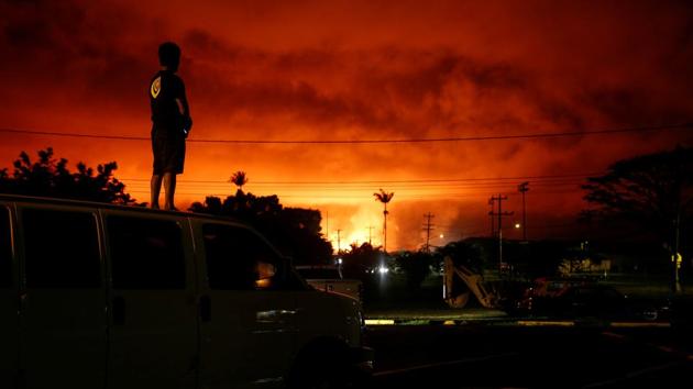 Darryl Sumiki, 52, of Hilo, watches as lava lights up the sky above Pahoa during ongoing eruptions of the Kilauea Volcano in Hawaii, USA. (Terray Sylvester / REUTERS)