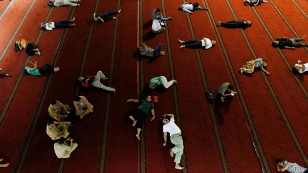 People sleep as they wait for iftar during at Istiqlal mosque in Jakarta, Indonesia. (Beawiharta / REUTERS)